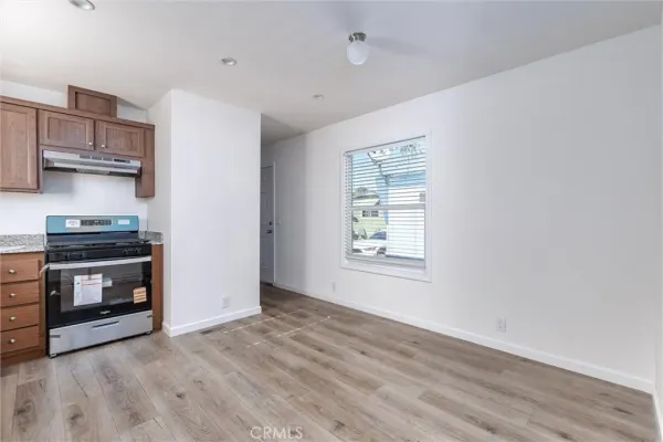 a kitchen with granite countertop a stove and a wooden floors