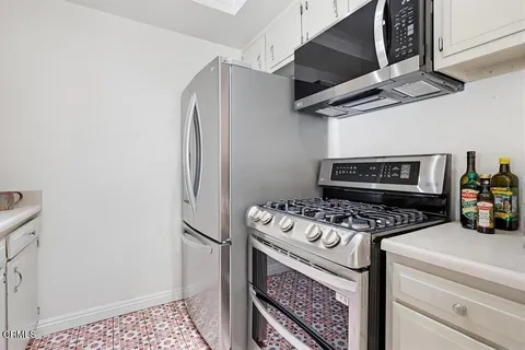 a kitchen with stainless steel appliances granite countertop a stove a refrigerator and a microwave