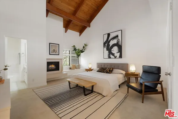 a bedroom with bed and a painting on the wall