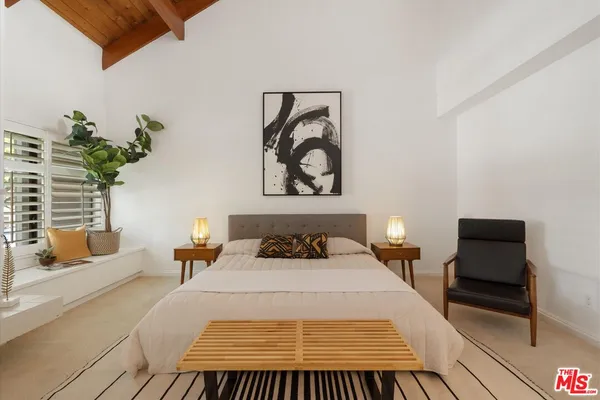 a bedroom with a bed and a painting on the wall