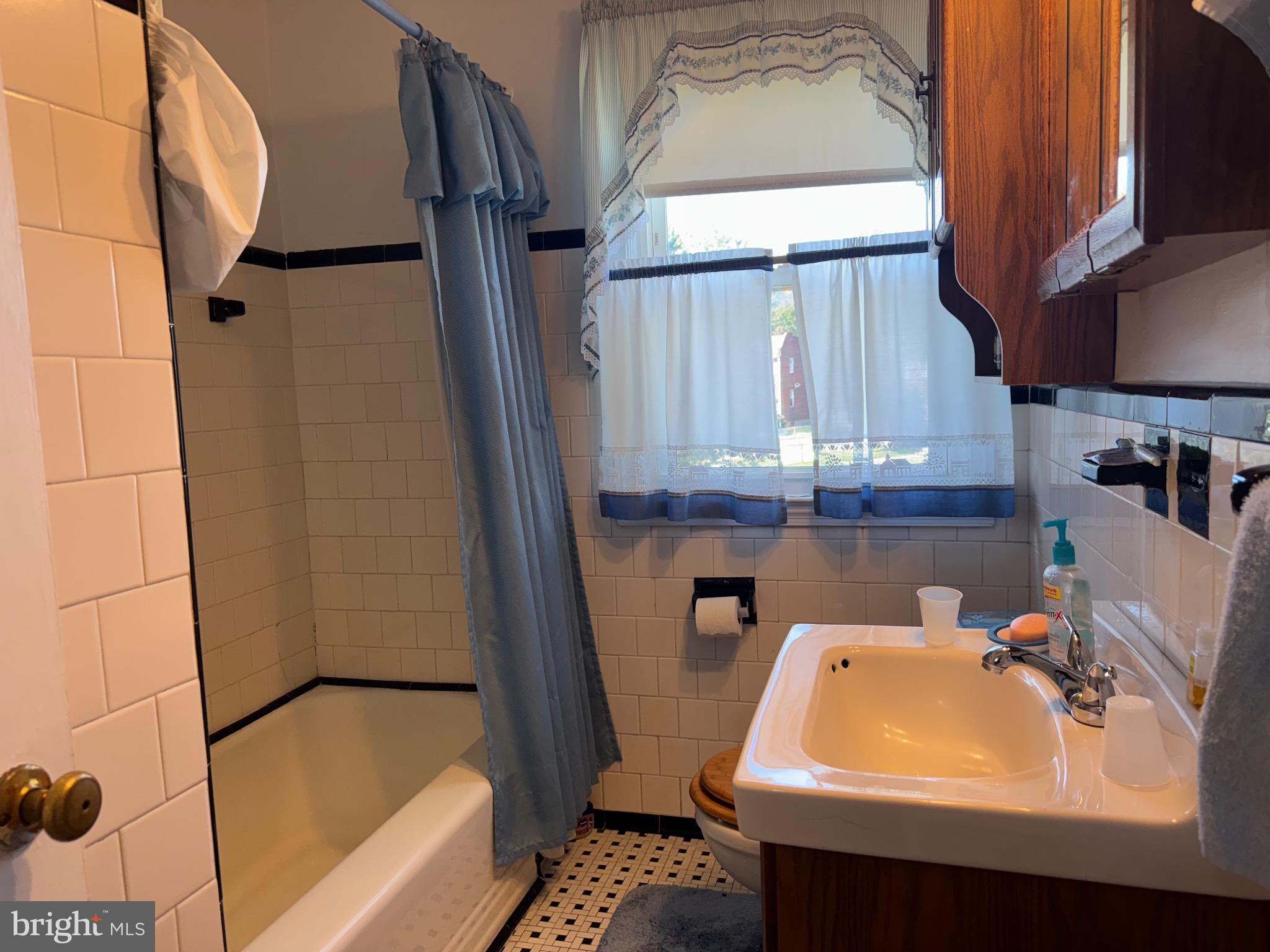 349 Grove Park Road Baltimore, MD 21225 - Photo 14 of 22 a bathroom with a sink a mirror and a bathtub