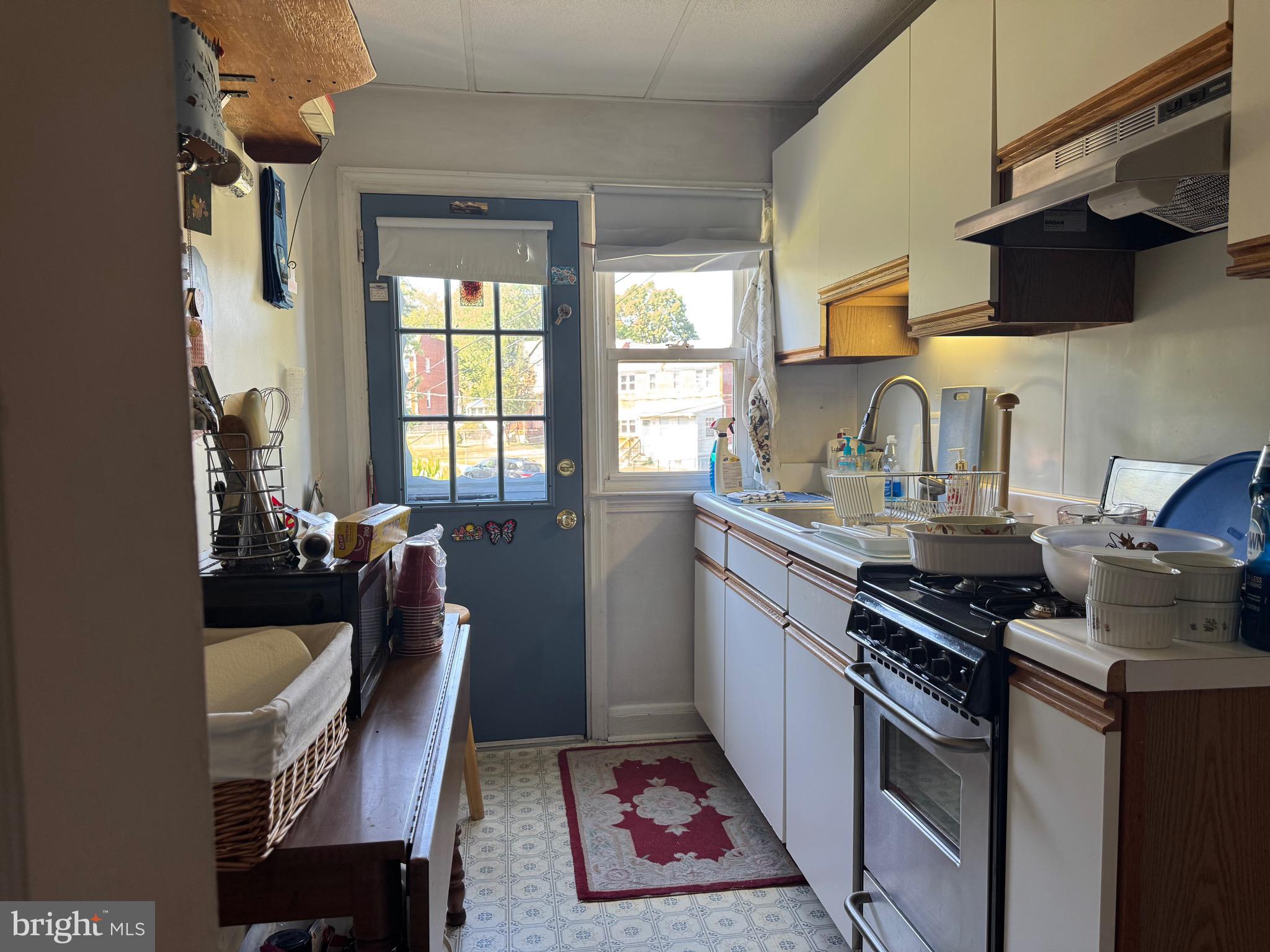 349 Grove Park Road Baltimore, MD 21225 - Photo 7 of 22 a kitchen with a stove a sink and a dining table with wooden floor