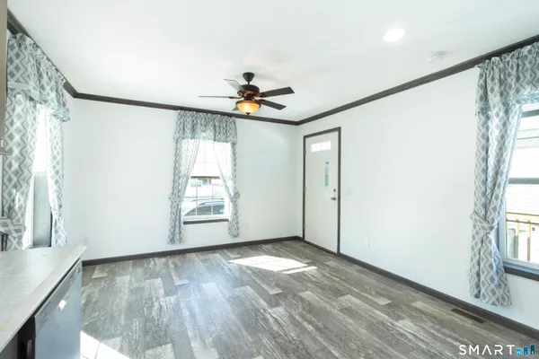 an empty room with wooden floor and windows