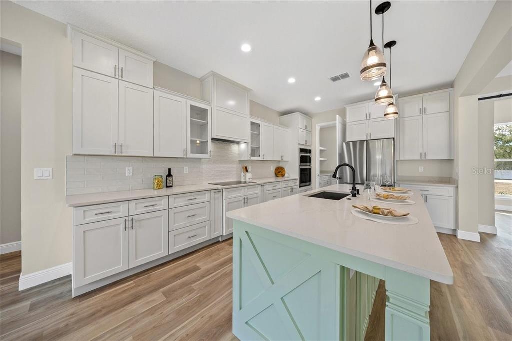 5315 Southwest 121st Terrace Ocala, FL 34481 - Photo 19 of 56 a kitchen with kitchen island a sink a stove cabinets and wooden floor