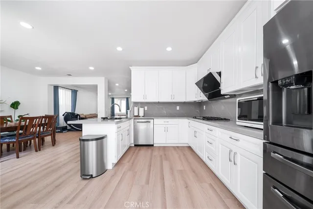 a large kitchen with stainless steel appliances lots of counter space and wooden floors
