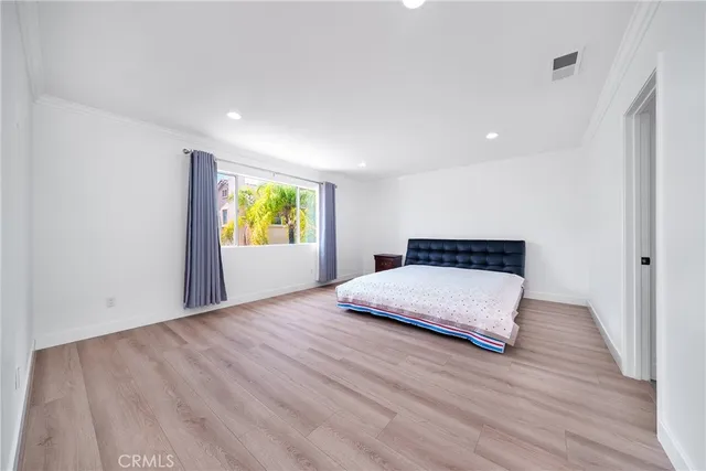 a spacious bedroom with a bed and a large window