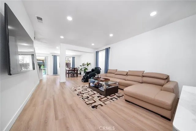 a living room with furniture wooden floor and a large window
