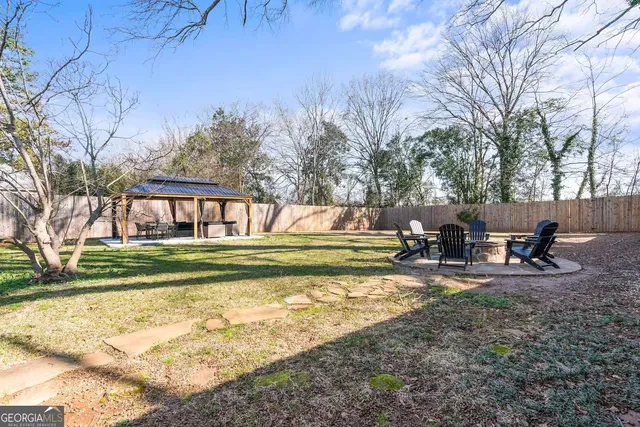 a view of a swimming pool with a bench and trees around