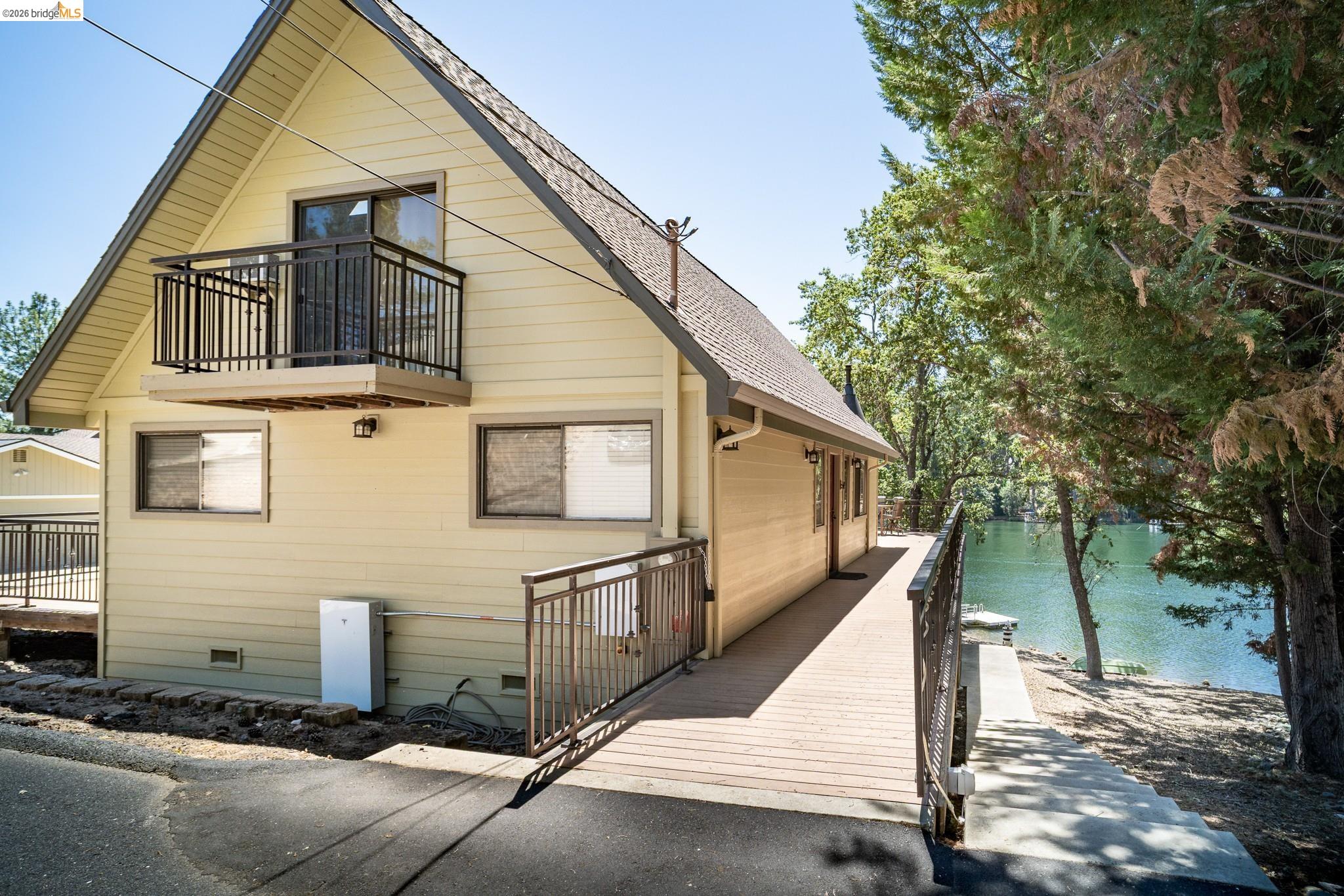 19711 Pleasantview Drive Groveland, CA 95321 - Photo 6 of 39 A-frame home featuring a second-story balcony with metal railings and a waterside location