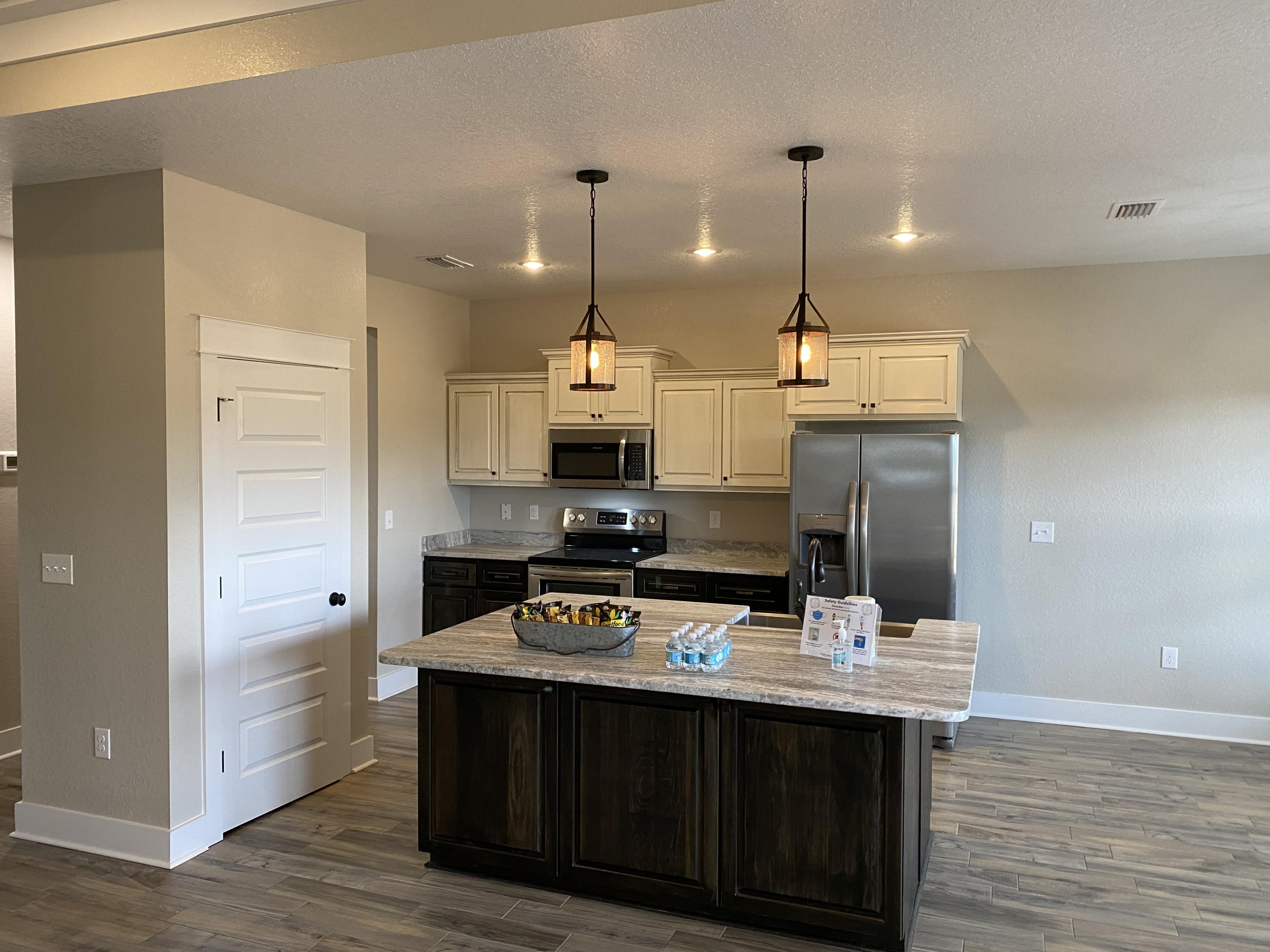 3950 Painter Branch Road Crestview, FL 32539 - Photo 3 of 18 a kitchen with stainless steel appliances kitchen island granite countertop a sink a stove and a wooden floors