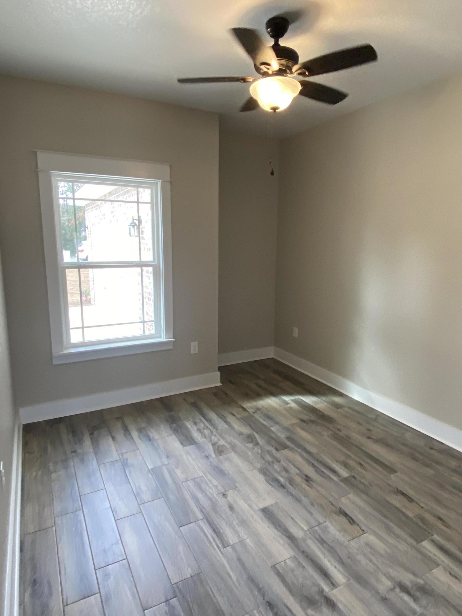 3950 Painter Branch Road Crestview, FL 32539 - Photo 8 of 18 a view of empty room with wooden floor and fan