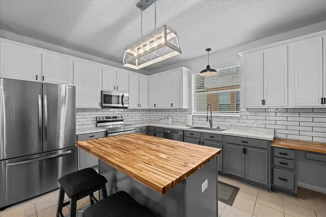 a kitchen with stainless steel appliances a sink a stove a refrigerator and cabinets