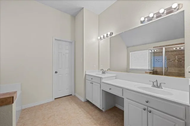 a bathroom with 2 sink tub and a mirror