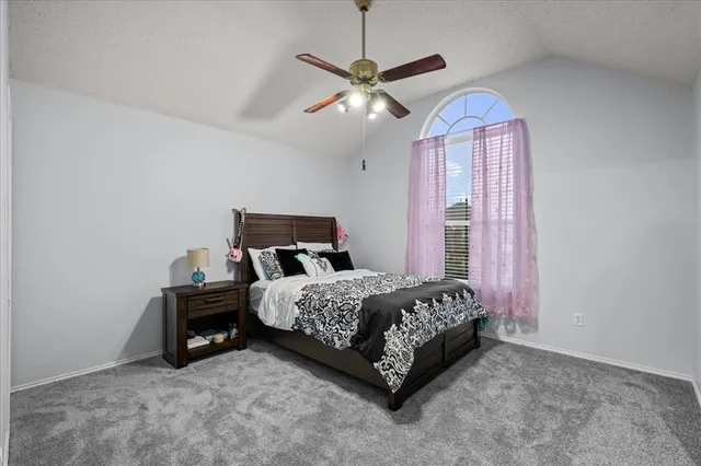 a bed sitting in a bedroom next to a window and a chandelier