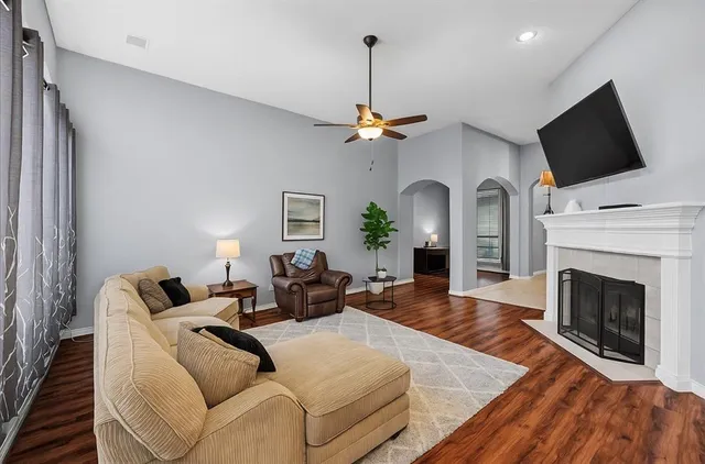 a living room with furniture a fireplace and a flat screen tv