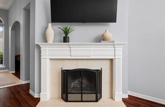 a living room with a fireplace and a potted plant