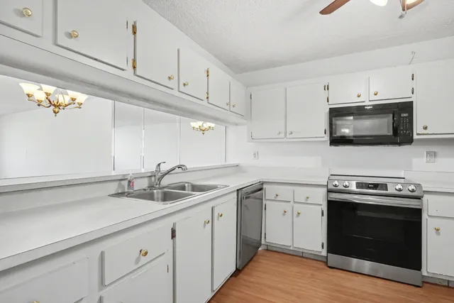 a kitchen with appliances a sink and cabinets