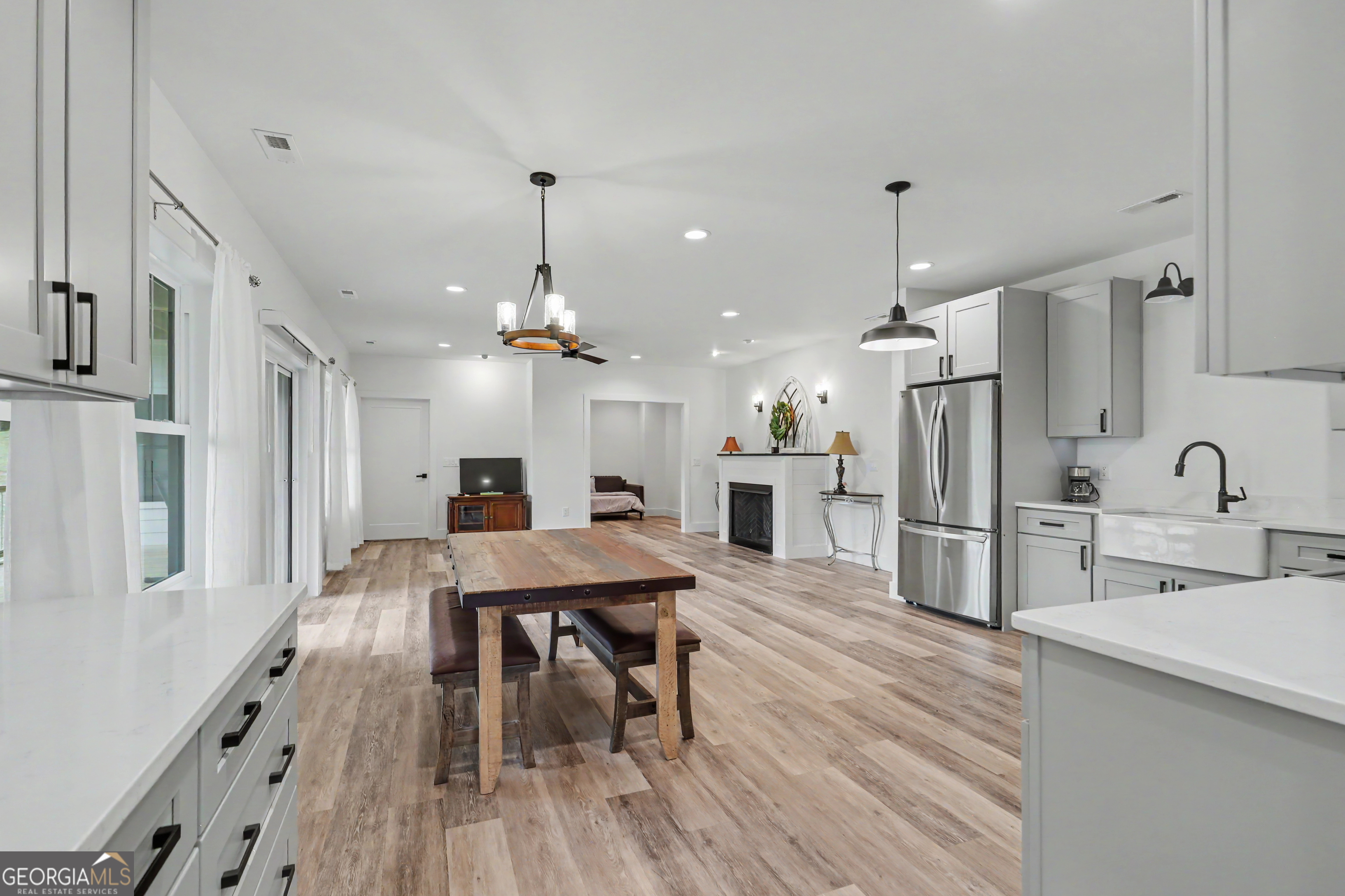 1424 Ridge Pointe Way Blairsville, GA 30512 - Photo 62 of 114 a kitchen with stainless steel appliances kitchen island granite countertop a refrigerator a sink dishwasher a stove and a dining table with wooden floor