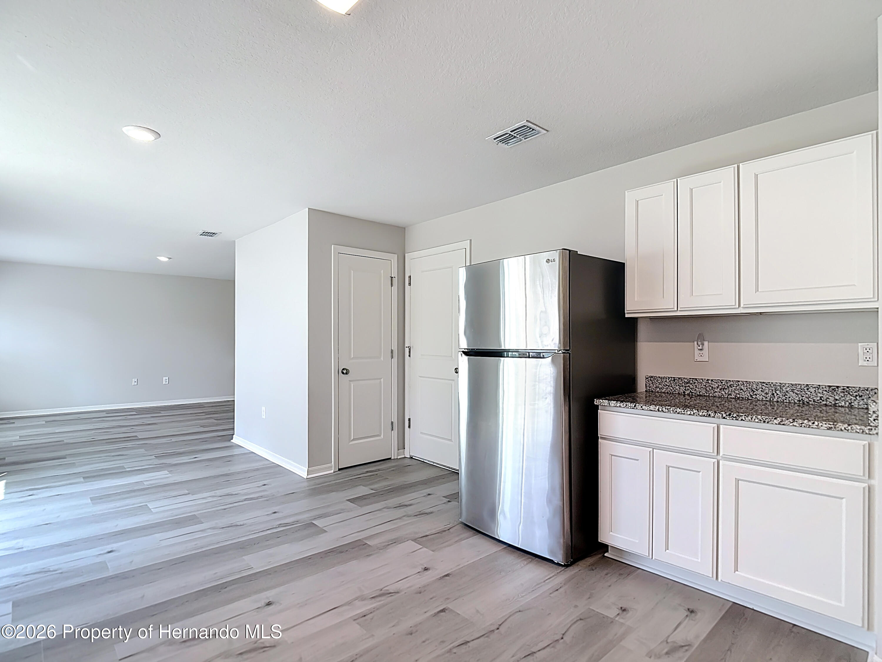11374 Marcella Avenue Weeki Wachee, FL 34614 - Photo 28 of 70 a kitchen with a refrigerator and a stove top oven