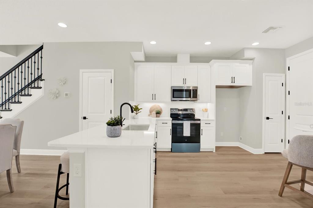 7765 93rd Street North Seminole, FL 33777 - Photo 5 of 29 a kitchen with stainless steel appliances kitchen island a refrigerator sink and white cabinets