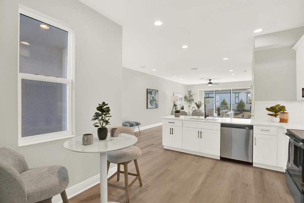 7765 93rd Street North Seminole, FL 33777 - Photo 7 of 29 a kitchen with white cabinets and table chair