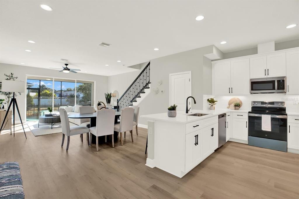 7765 93rd Street North Seminole, FL 33777 - Photo 8 of 29 a large white kitchen with stainless steel appliances granite countertop a stove and a wooden floors