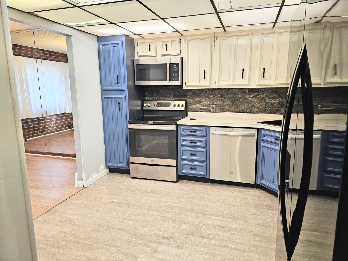 1420 Woodbridge Road, Unit 1E Joliet, IL 60436 - Photo 7 of 17 a kitchen with stainless steel appliances a stove a refrigerator and cabinets