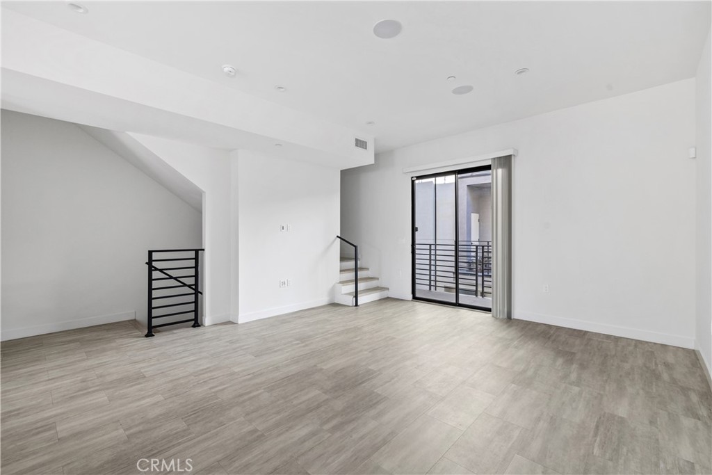 6719 Sepulveda Boulevard Van Nuys, CA 91406 - Photo 15 of 60 a view of an empty room with wooden floor and a window