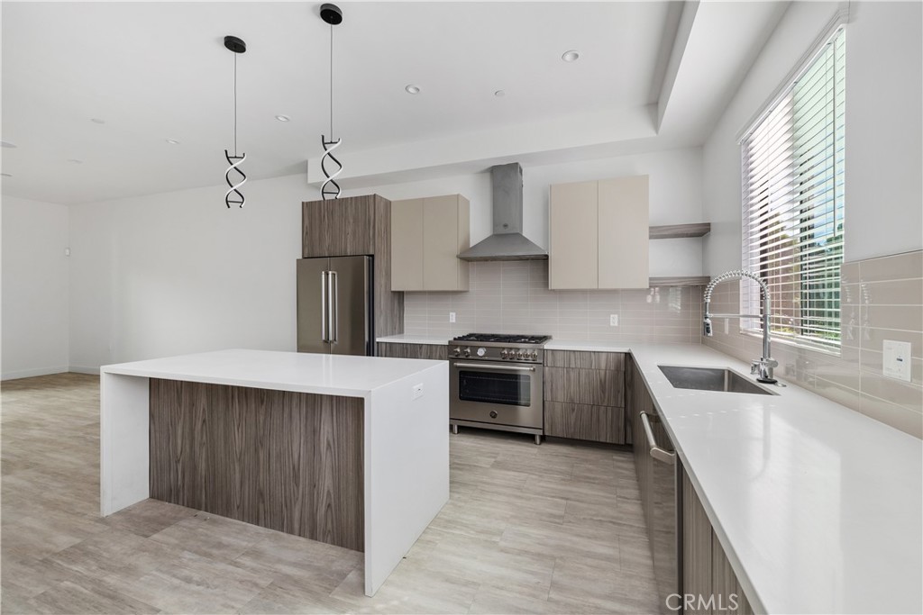 6719 Sepulveda Boulevard Van Nuys, CA 91406 - Photo 21 of 60 a kitchen with stainless steel appliances granite countertop a sink stove and refrigerator