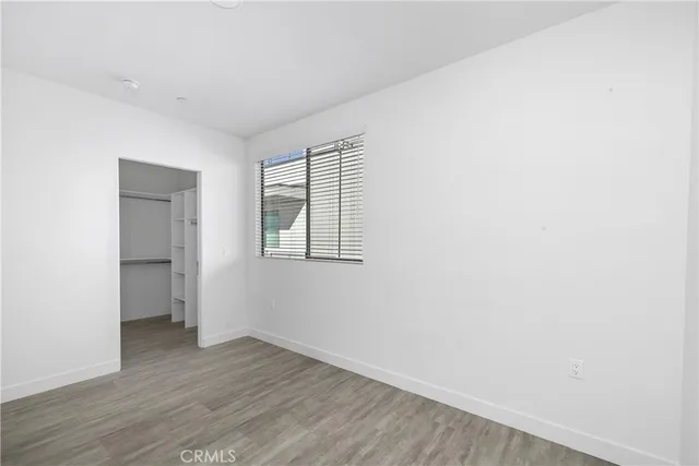 an empty room with wooden floor and sliding door