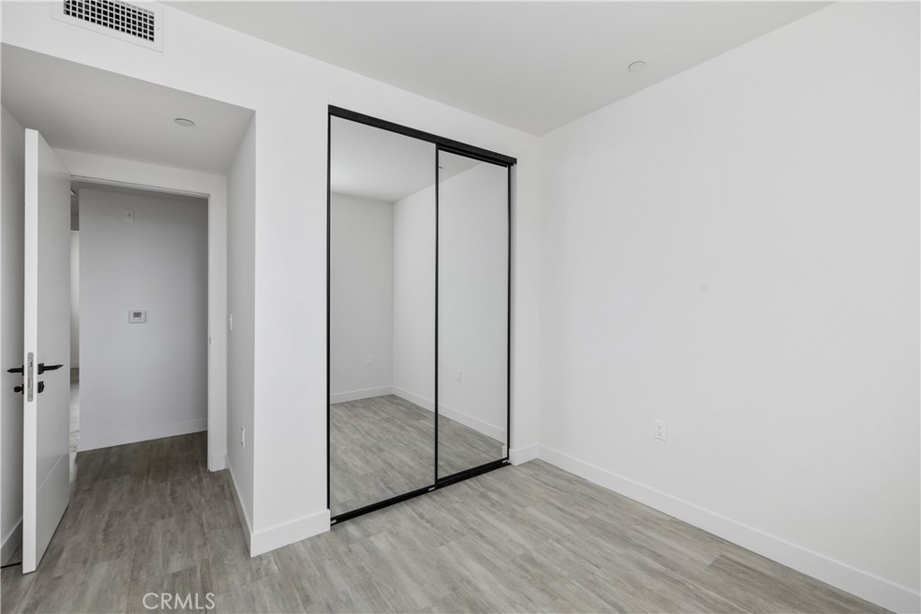 6719 Sepulveda Boulevard Van Nuys, CA 91406 - Photo 48 of 60 an empty room with wooden floor and sliding door