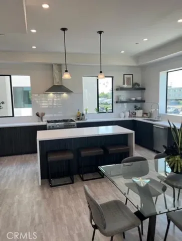 a kitchen with stainless steel appliances kitchen island granite countertop a refrigerator and a stove top oven