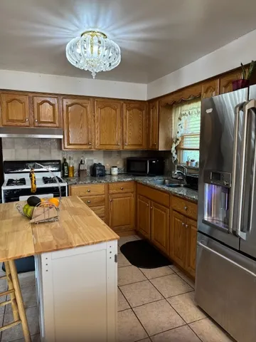 a kitchen with granite countertop stainless steel appliances a stove top oven a sink a counter space and cabinets