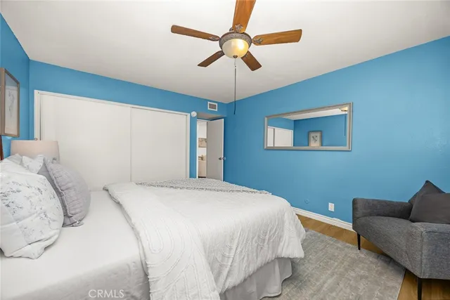 a bedroom with a bed ceiling fan and a window