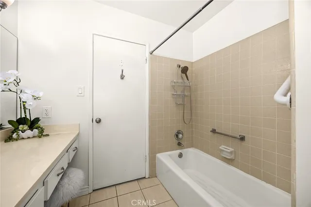 a bathroom with a tub shower sink and mirror