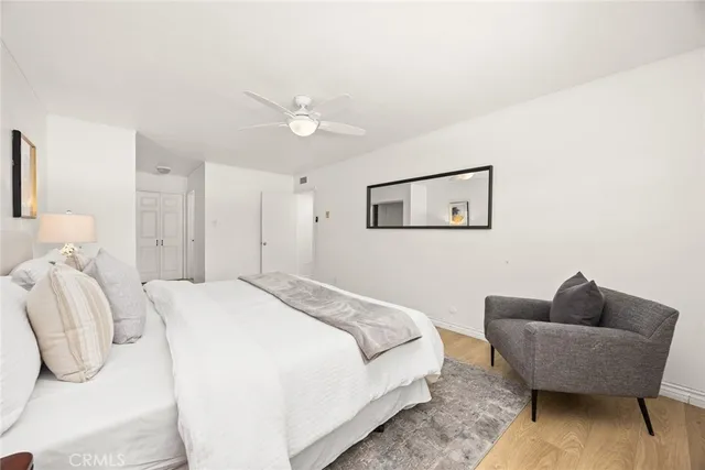 a spacious bedroom with a bed a couch and a chandelier