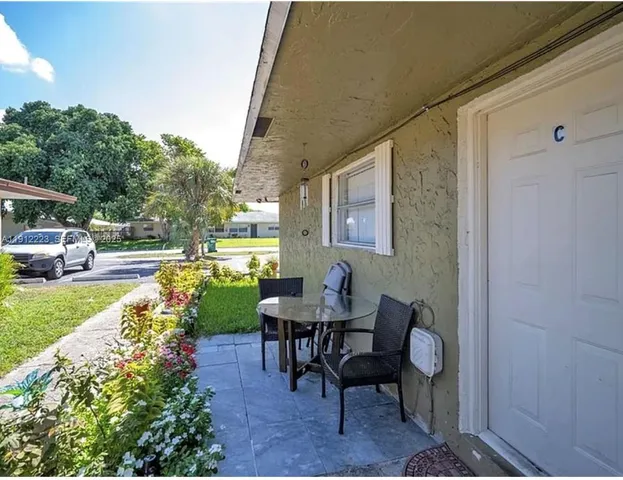 a view of a chair and table in backyard of the house