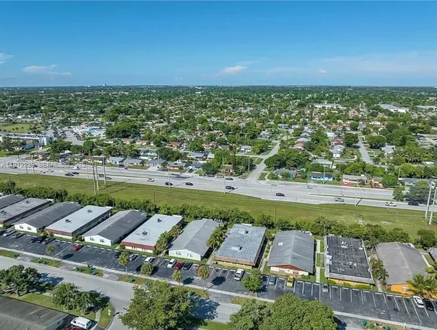an aerial view of a city with lots of residential buildings ocean and mountain view in back