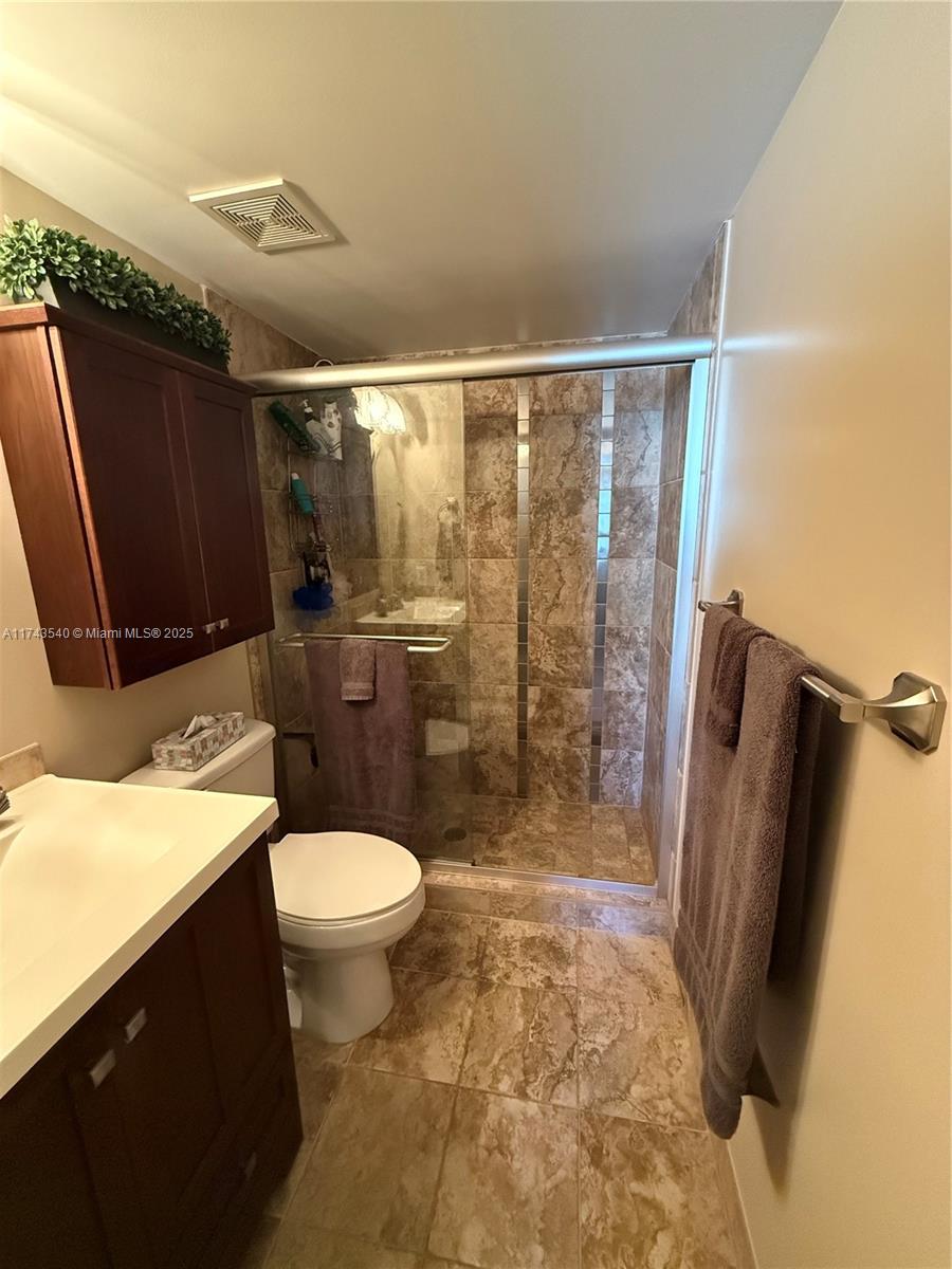 609 Waterside Drive, Unit 609 Hypoluxo, FL 33462 - Photo 12 of 33 a bathroom with a sink a toilet a mirror and shower
