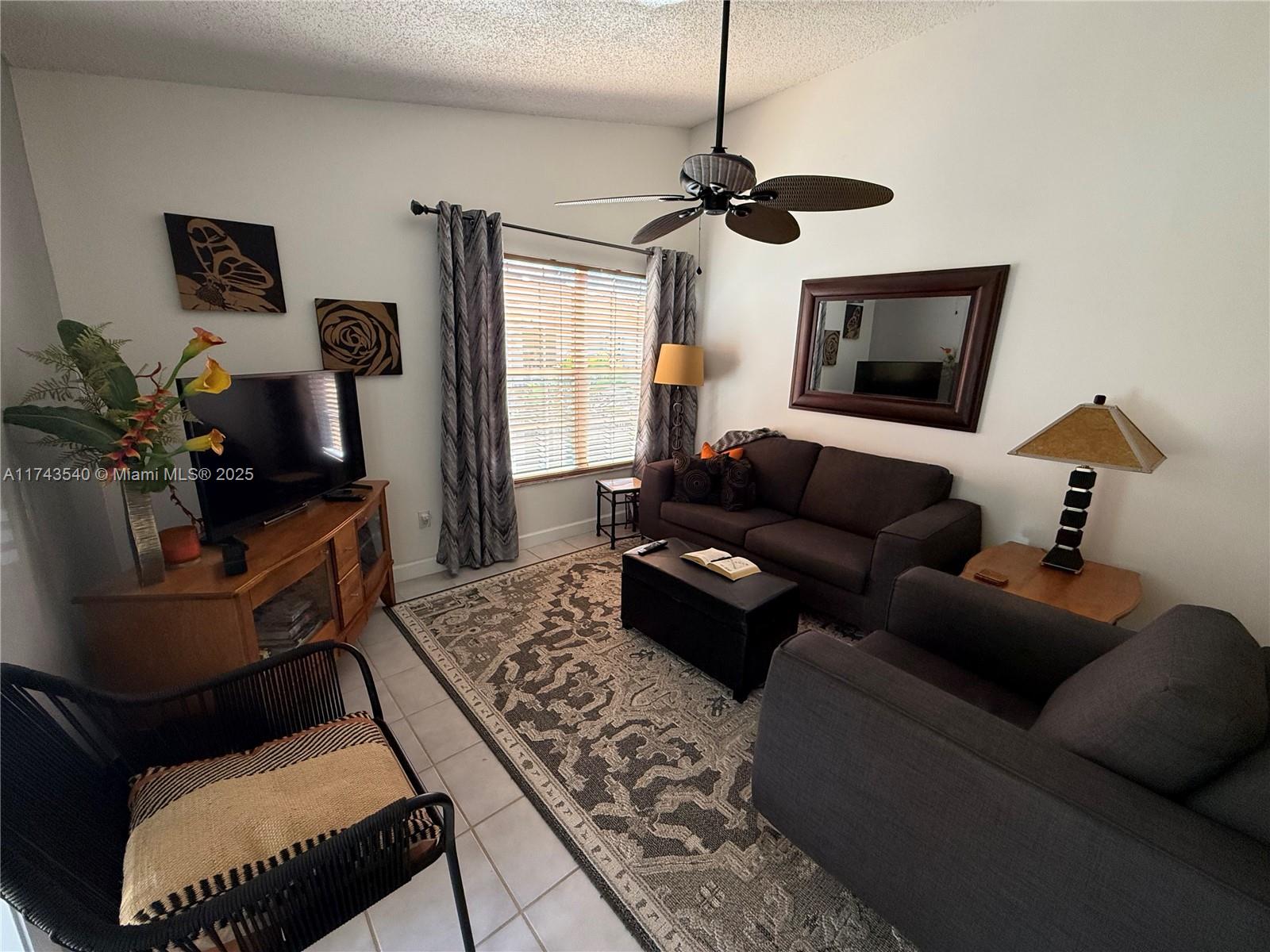 609 Waterside Drive, Unit 609 Hypoluxo, FL 33462 - Photo 2 of 33 a living room with furniture and a flat screen tv