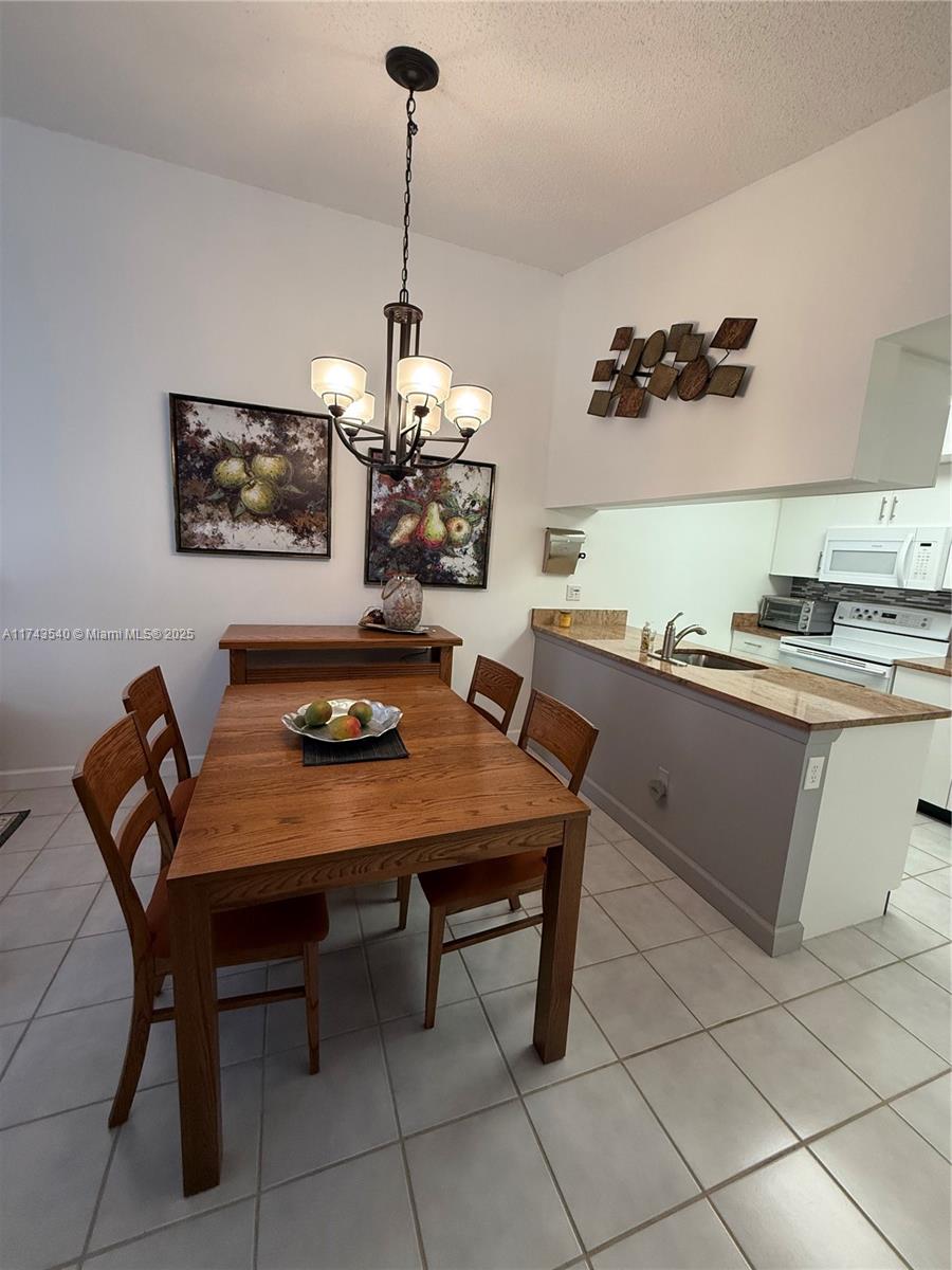 609 Waterside Drive, Unit 609 Hypoluxo, FL 33462 - Photo 25 of 33 a view of a dining room furniture and chandelier
