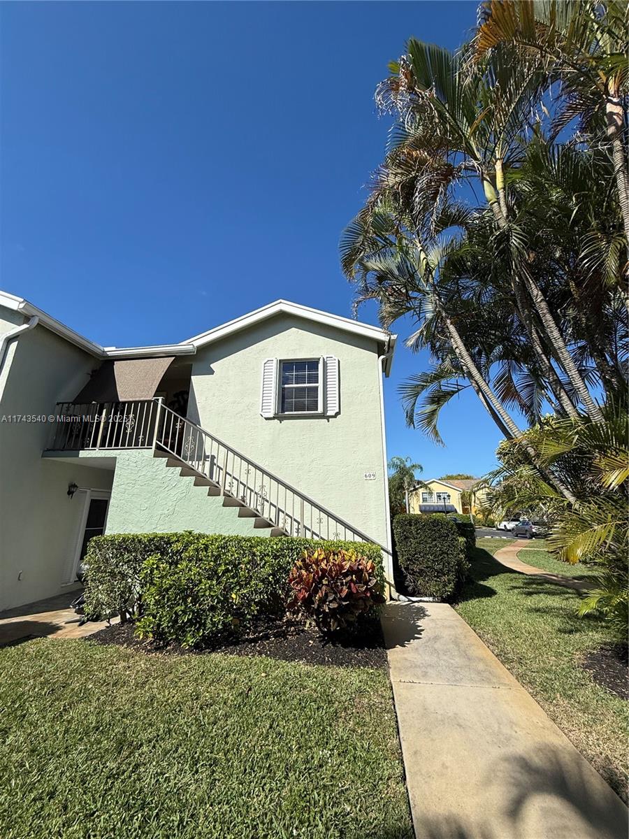 609 Waterside Drive, Unit 609 Hypoluxo, FL 33462 - Photo 4 of 33 a front view of a house with a yard