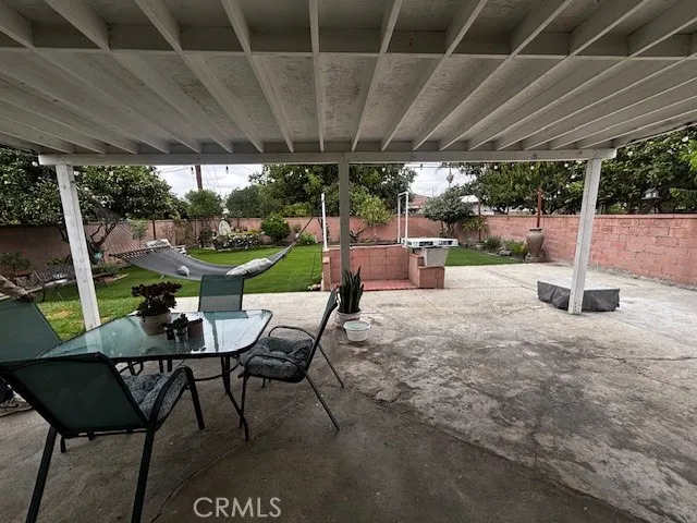 a view of a patio with a table chairs and a backyard