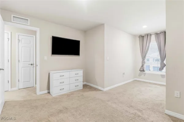 an empty room with furniture and a flat screen tv