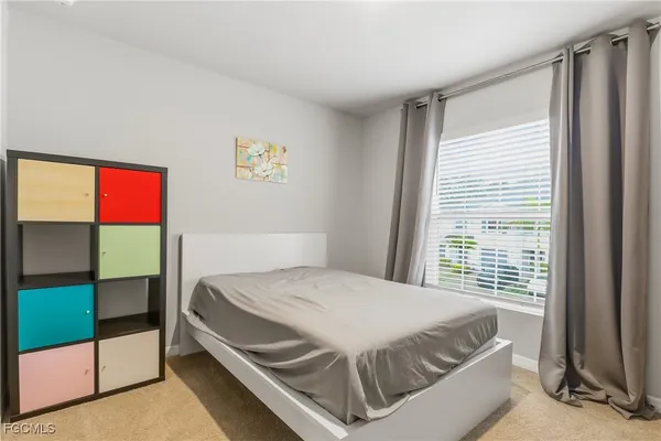 a bedroom with a bed and a dresser next to a window