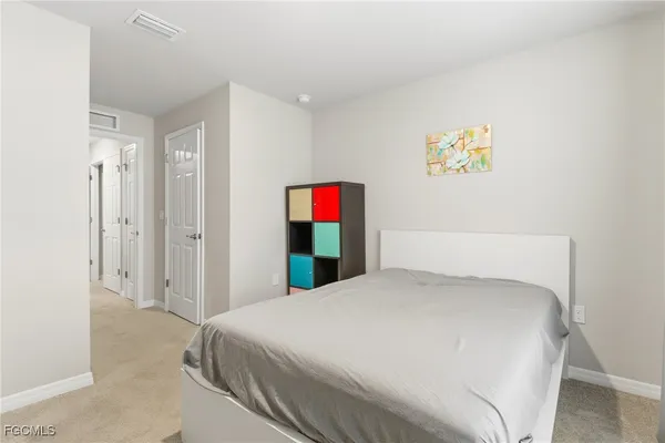 a bedroom with a bed and a painting on the wall