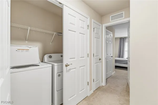a view of a storage & utility room with closet dryer