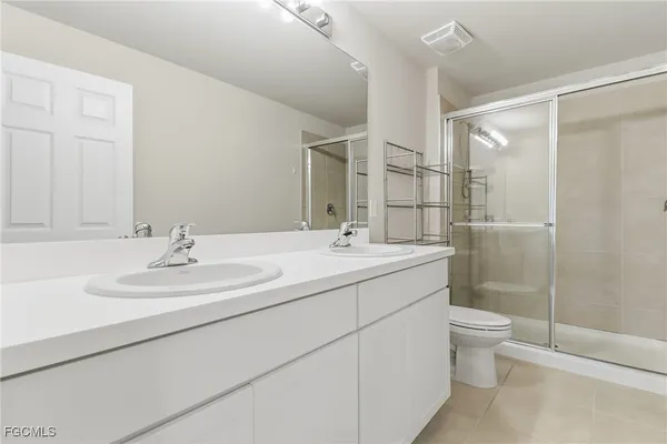 a bathroom with a double vanity sink toilet and shower