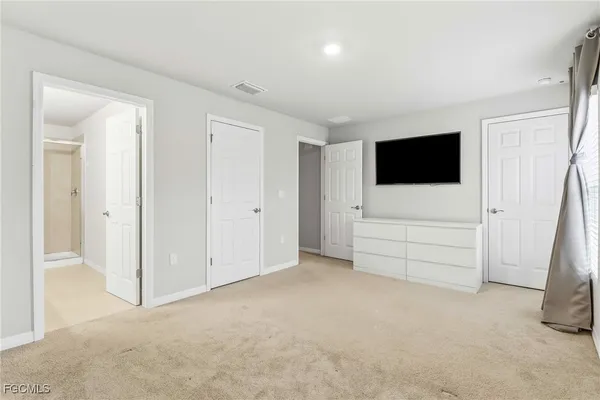 an empty room with furniture and a flat screen tv