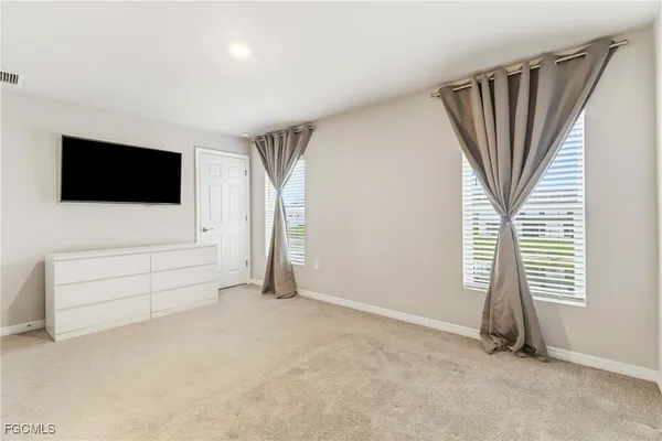 an empty room with windows and flat screen tv